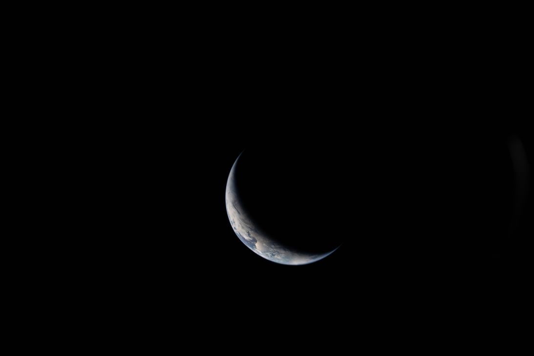 Earth appears as a crescent on the third day of the mission.