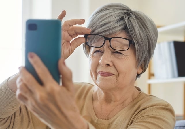 woman squinting at a phone