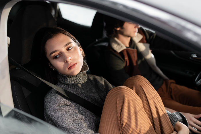 Young woman in a car, looking distressed and lost in thought, depicting 22-year-old experiencing hallucinations.