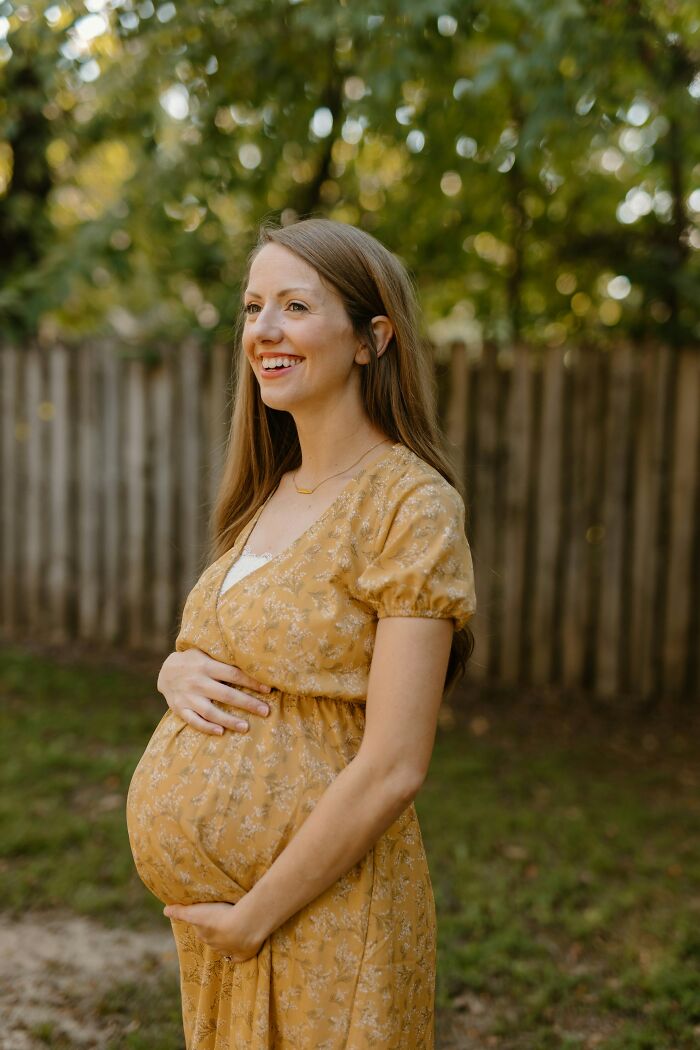 Pregnant woman in a yellow dress smiling outdoors, illustrating weird and interesting medical facts about pregnancy.
