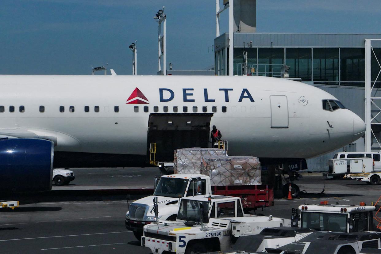 FILE PHOTO: A staff uploads packages on Delta Air Lines plane at John F. Kennedy International Airport in Queens, New York City, U.S., April 23, 2025. REUTERS/Jeenah Moon/File Photo