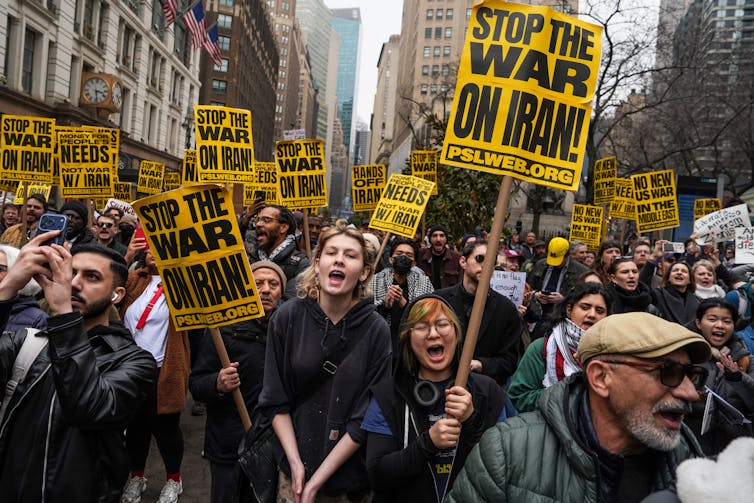 Protesters hold placards reading 'stop the war on Iran!'
