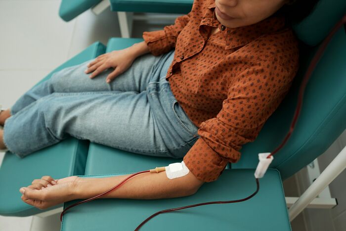 Person in a red patterned shirt donating blood, illustrating weird and interesting medical facts about human health.