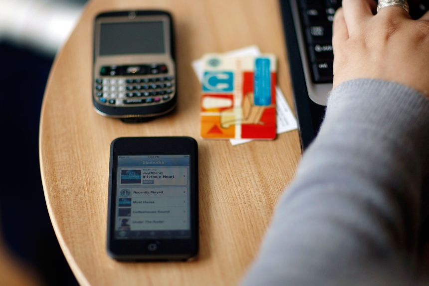 Michelle Zorich's iPhone captures a song as she uses her computer at a Starbucks October 2, 2007 in Miami Beach, Florida.