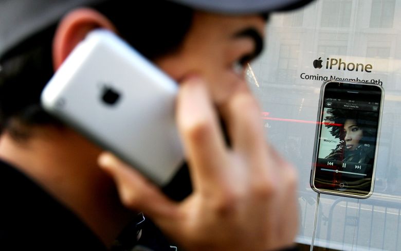 A man uses an Apple iPhone outside the Apple store on Regent Street on device's UK launch day, November 9, 2007 in London, England.