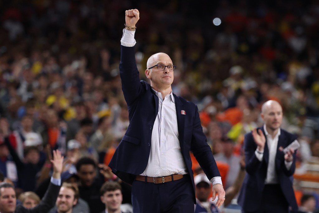 UConn coach Dan Hurley celebrates on the basketball court.
