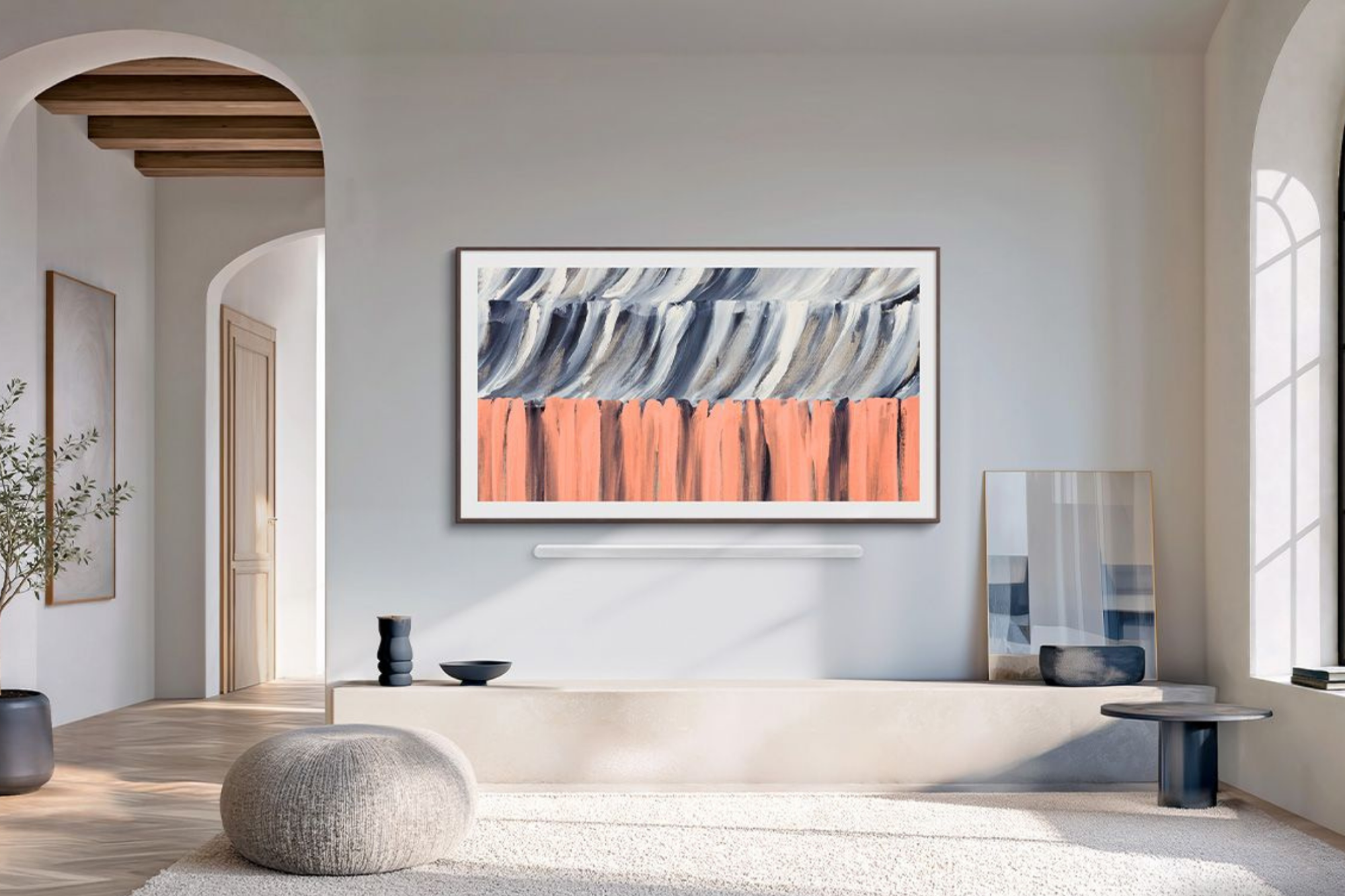 Samsung The Frame TV hanging on wall near large window and potted tree