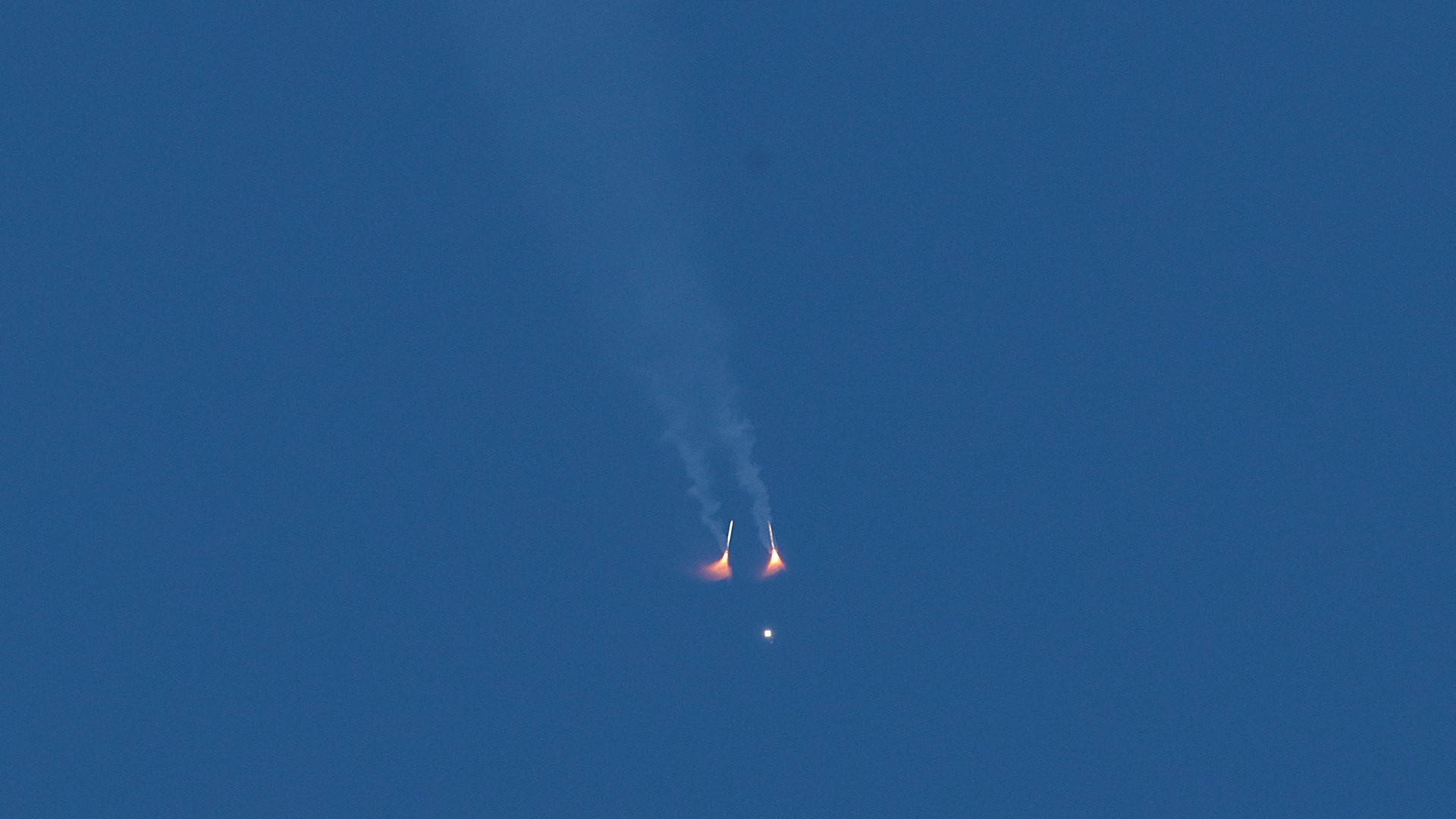 a rocket launches into a blue sky