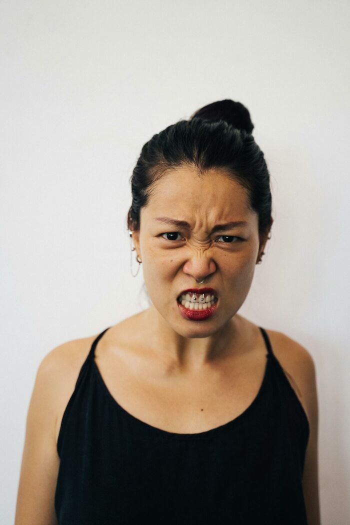 Young woman with braces showing anger, illustrating weird and interesting medical facts about human expressions.