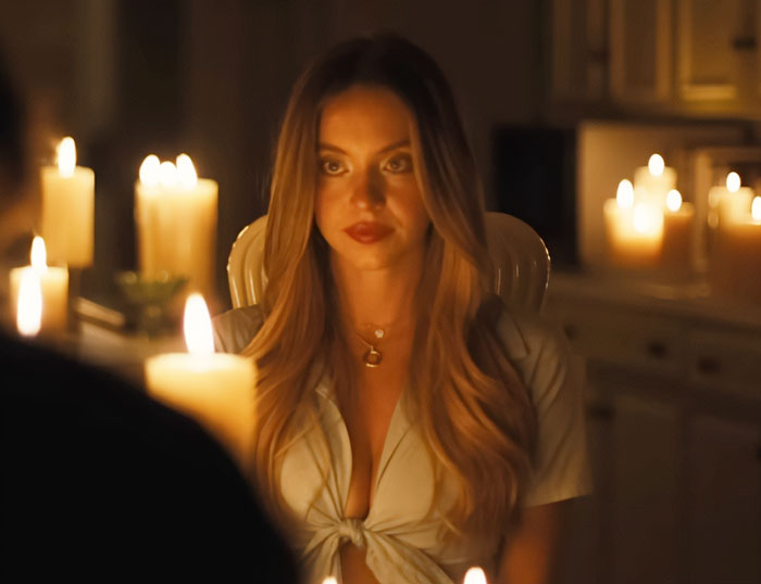 Sydney Sweeney in a dimly lit room surrounded by candles, highlighting her look in new Euphoria season scenes.