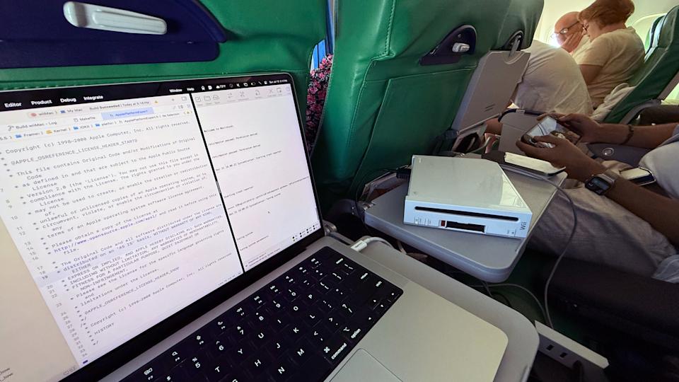 Photo of an airplane, where a Wii sits next to a MacBook with code on its screen